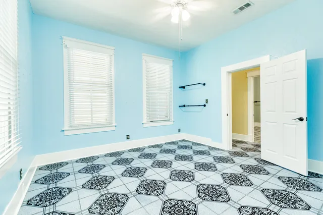 a view of a bedroom with wooden floor and a bathroom