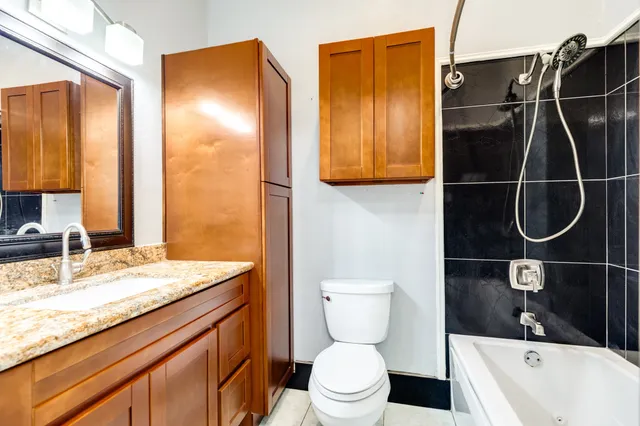 a bathroom with a granite countertop sink toilet and shower