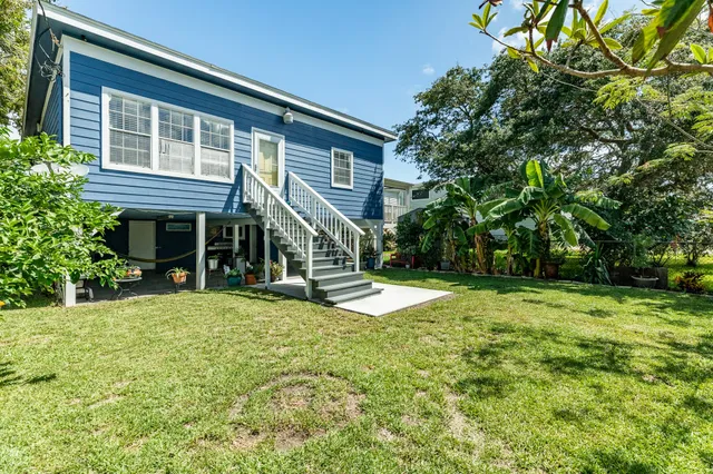 a view of a house with a yard and tree