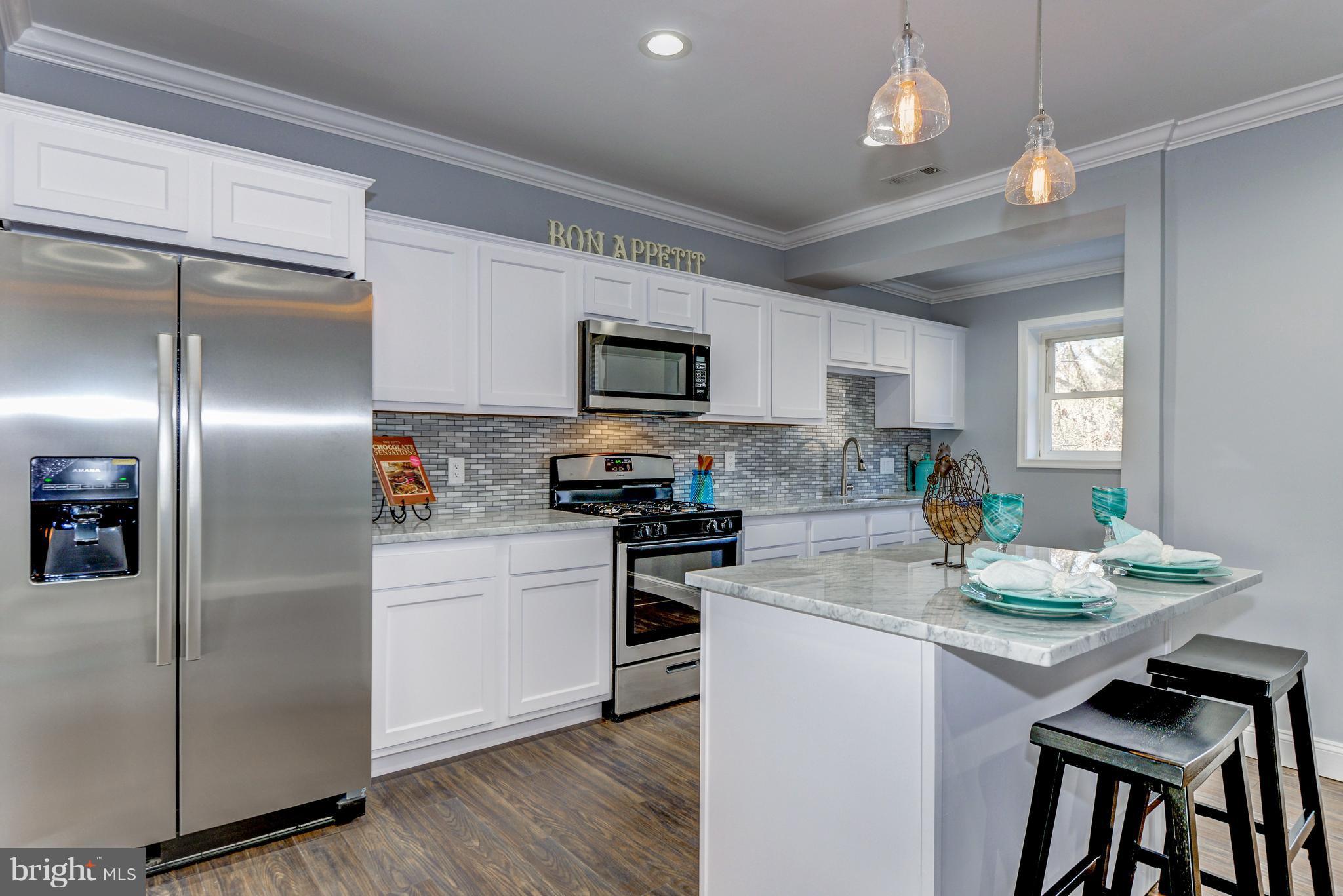 4622 Rokeby Road Baltimore, MD 21229 - Photo 9 of 27 a kitchen with refrigerator cabinets and wooden floor
