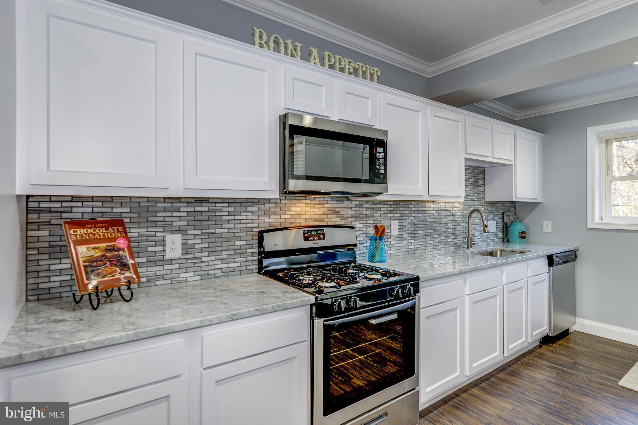 4622 Rokeby Road Baltimore, MD 21229 - Photo 10 of 27 a kitchen with stainless steel appliances granite countertop grey cabinets a stove a sink and dishwasher