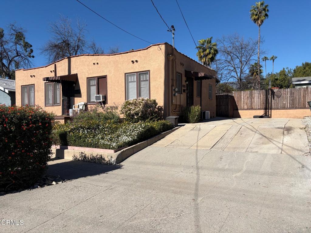 a view of a white building among the street with palm trees