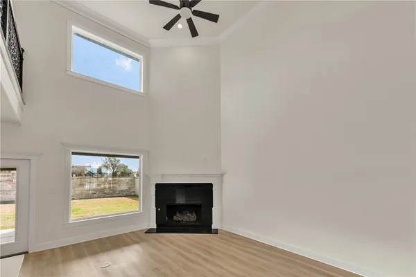 an empty room with windows and fireplace