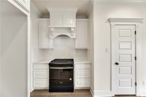a kitchen with white cabinets and a stove