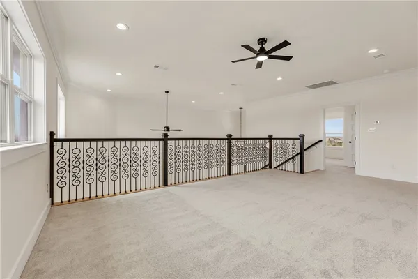 an empty room with a ceiling fan and window