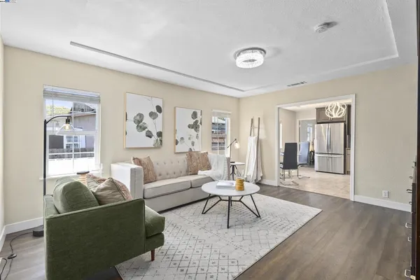 a kitchen with stainless steel appliances granite countertop a stove top oven a refrigerator a sink dishwasher a dining table and chairs with wooden floor