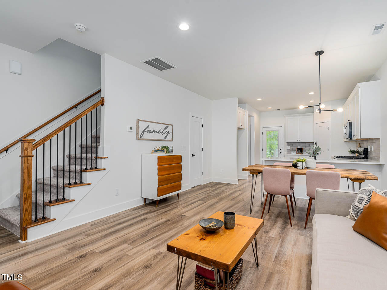 614 East Ellerbee Street Durham, NC 27704 - Photo 3 of 12 a kitchen with stainless steel appliances kitchen island granite countertop a table chairs in it and wooden floors