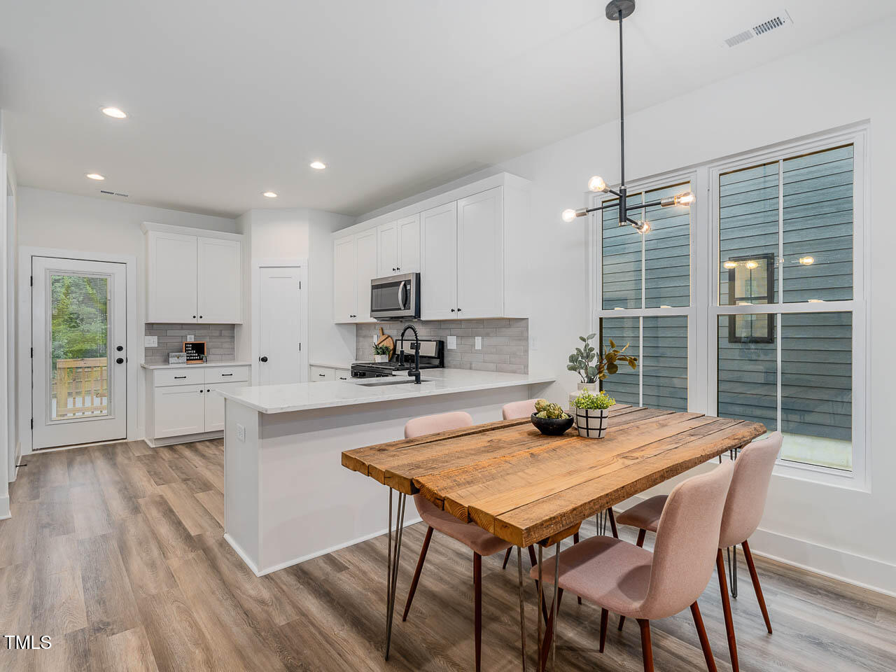 614 East Ellerbee Street Durham, NC 27704 - Photo 5 of 12 a kitchen with a dining table chairs and wooden floor