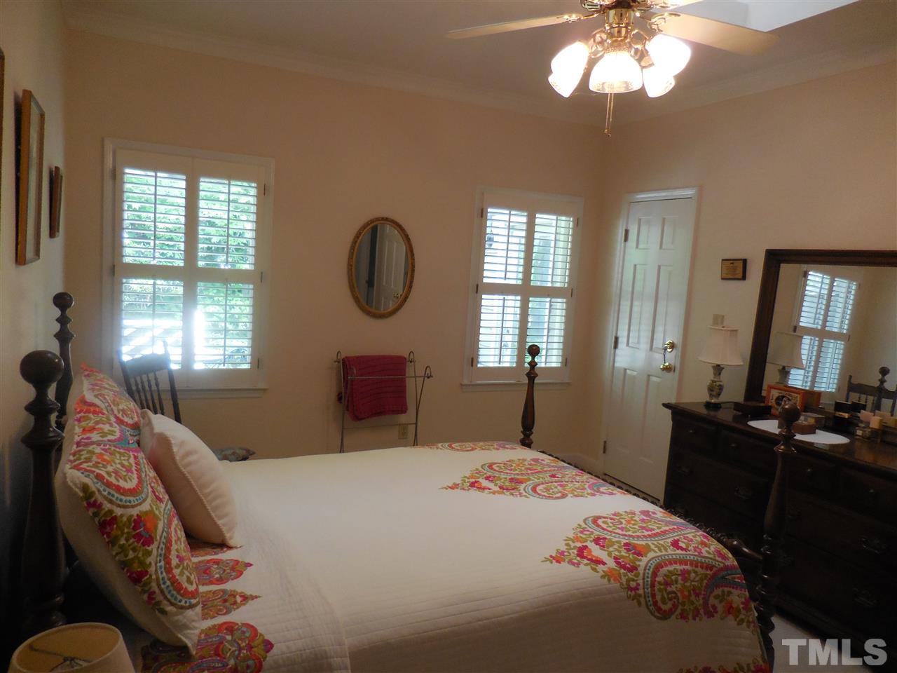 1307 Slatestone Court Raleigh, NC 27615 - Photo 14 of 25 a bedroom with a bed and a chandelier