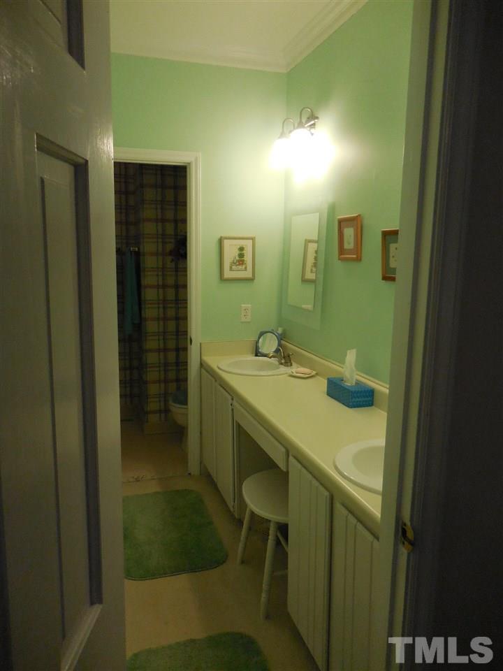 1307 Slatestone Court Raleigh, NC 27615 - Photo 15 of 25 a bathroom with a sink and a mirror