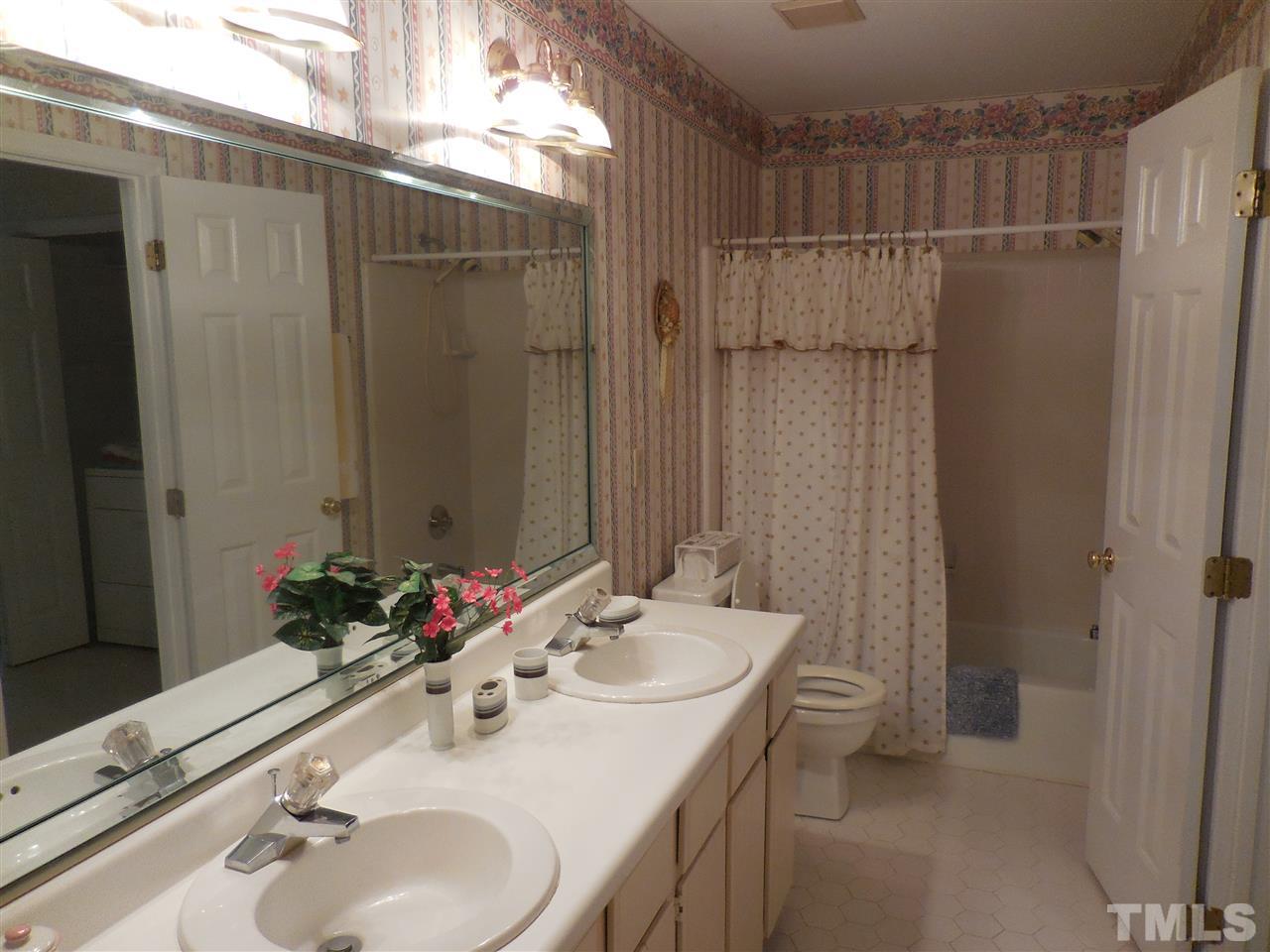 1307 Slatestone Court Raleigh, NC 27615 - Photo 19 of 25 a bathroom with a sink and a mirror