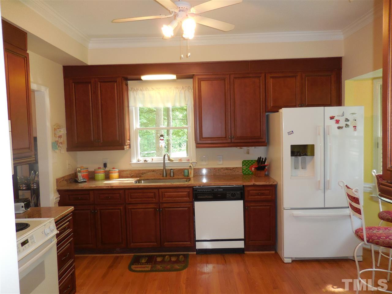 1307 Slatestone Court Raleigh, NC 27615 - Photo 4 of 25 a kitchen with a sink a stove a refrigerator and cabinets