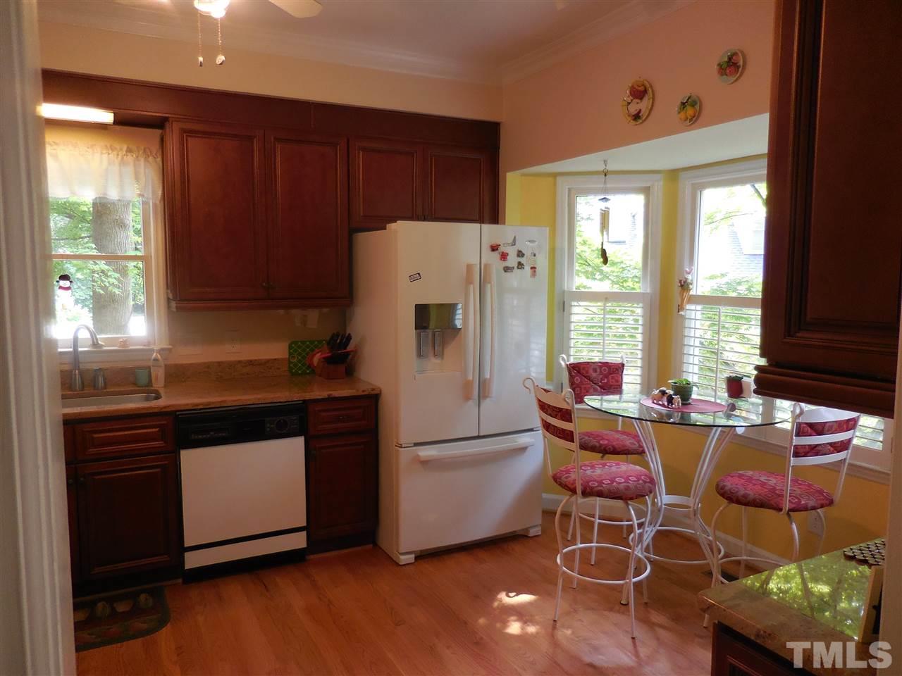 1307 Slatestone Court Raleigh, NC 27615 - Photo 5 of 25 a kitchen with stainless steel appliances a refrigerator a stove a sink and a dining table with garden view