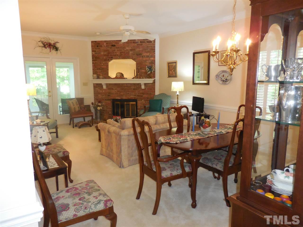 1307 Slatestone Court Raleigh, NC 27615 - Photo 8 of 25 a dining room with furniture a fireplace and a chandelier