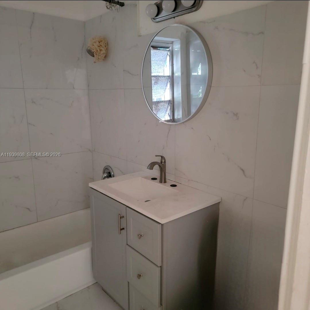 63 Northwest 68th Terrace, Unit 63 Miami, FL 33150 - Photo 5 of 5 a bathroom with a sink and a mirror