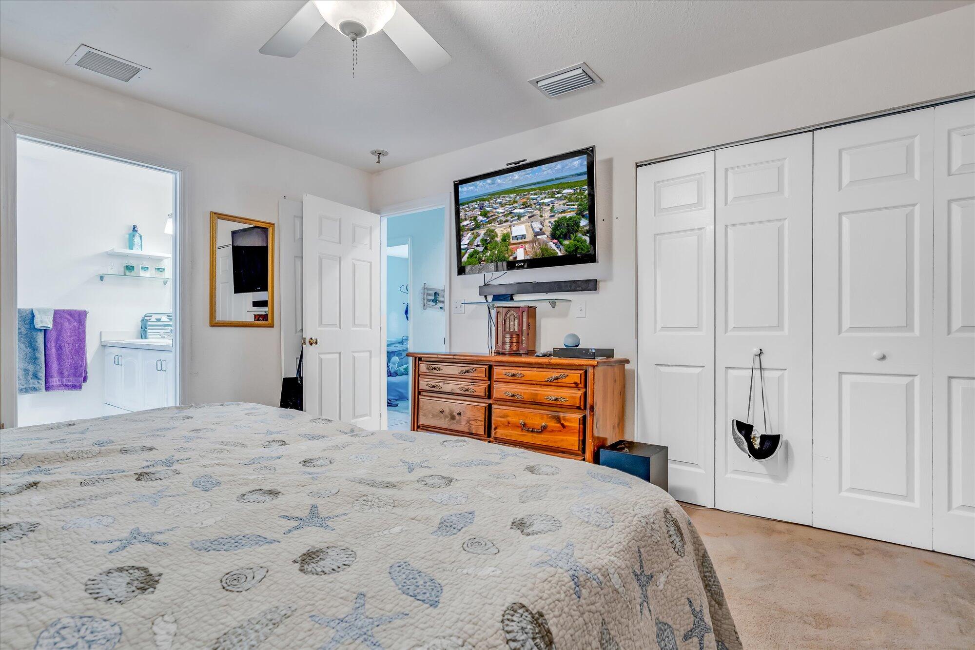 939 Plantation Road Key Largo, FL 33037 - Photo 14 of 38 a bedroom with a bed and a flat screen tv
