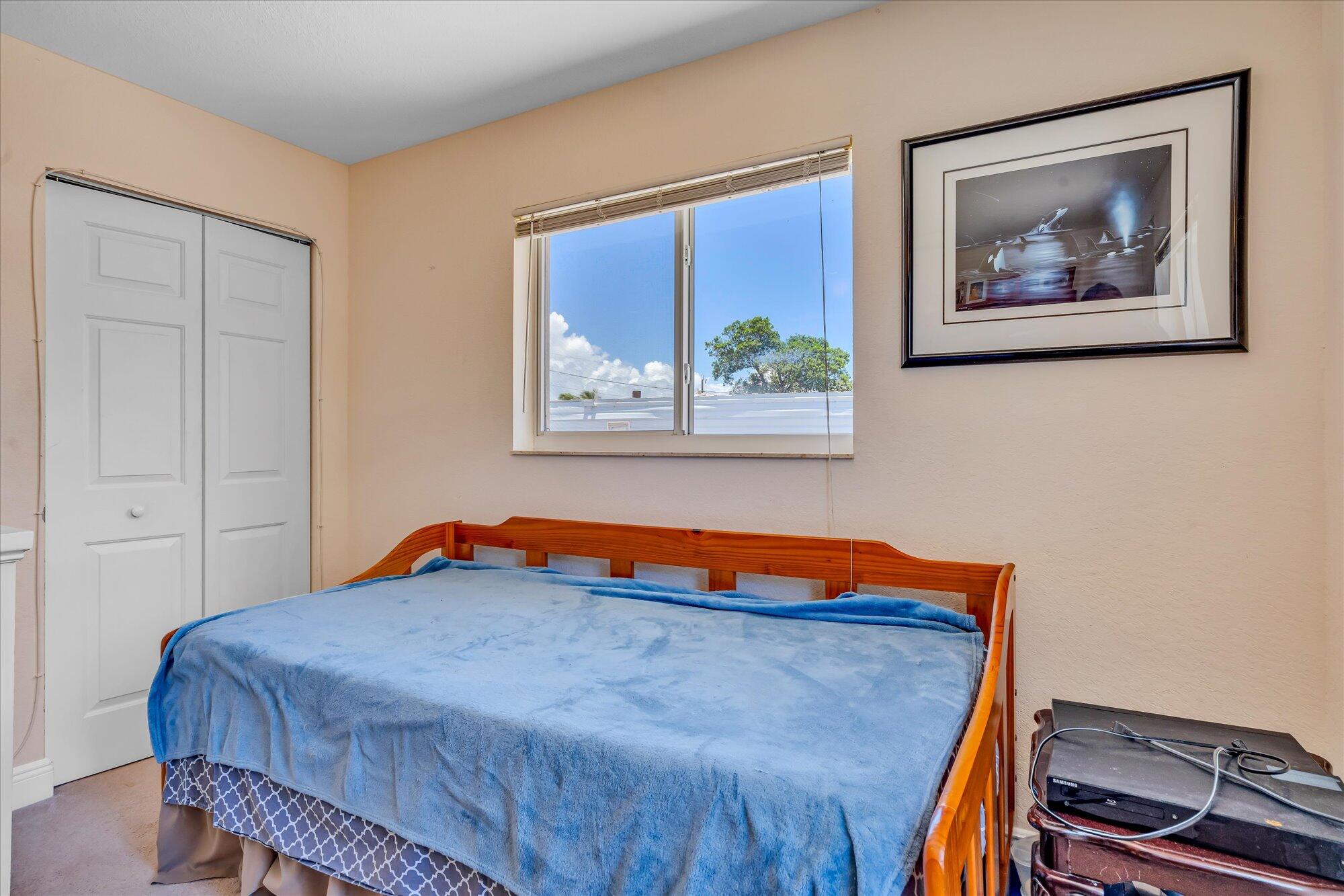 939 Plantation Road Key Largo, FL 33037 - Photo 20 of 38 a blue bed sitting in a bedroom next to a window