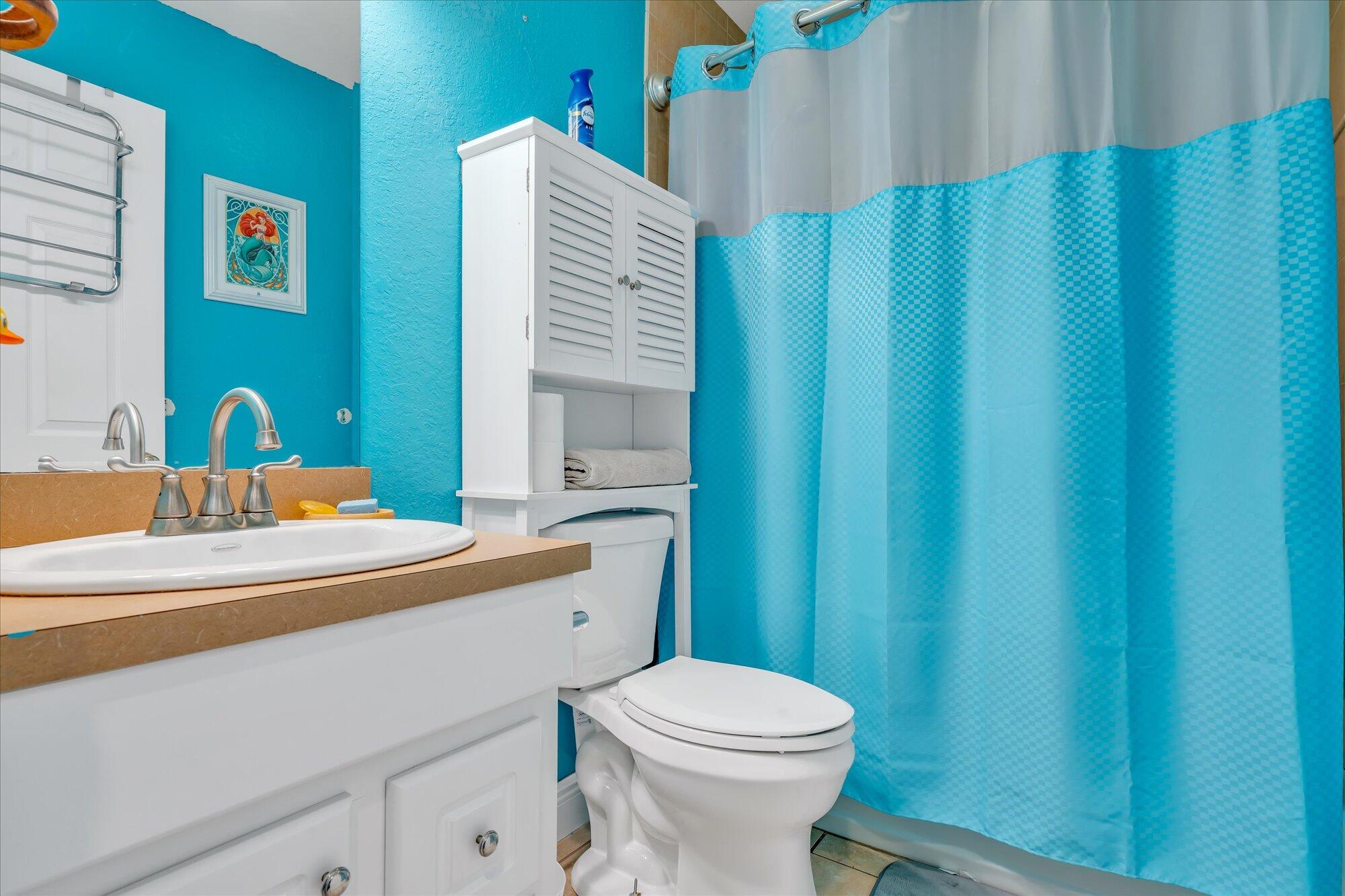 939 Plantation Road Key Largo, FL 33037 - Photo 22 of 38 a bathroom with a sink a toilet and shower curtain