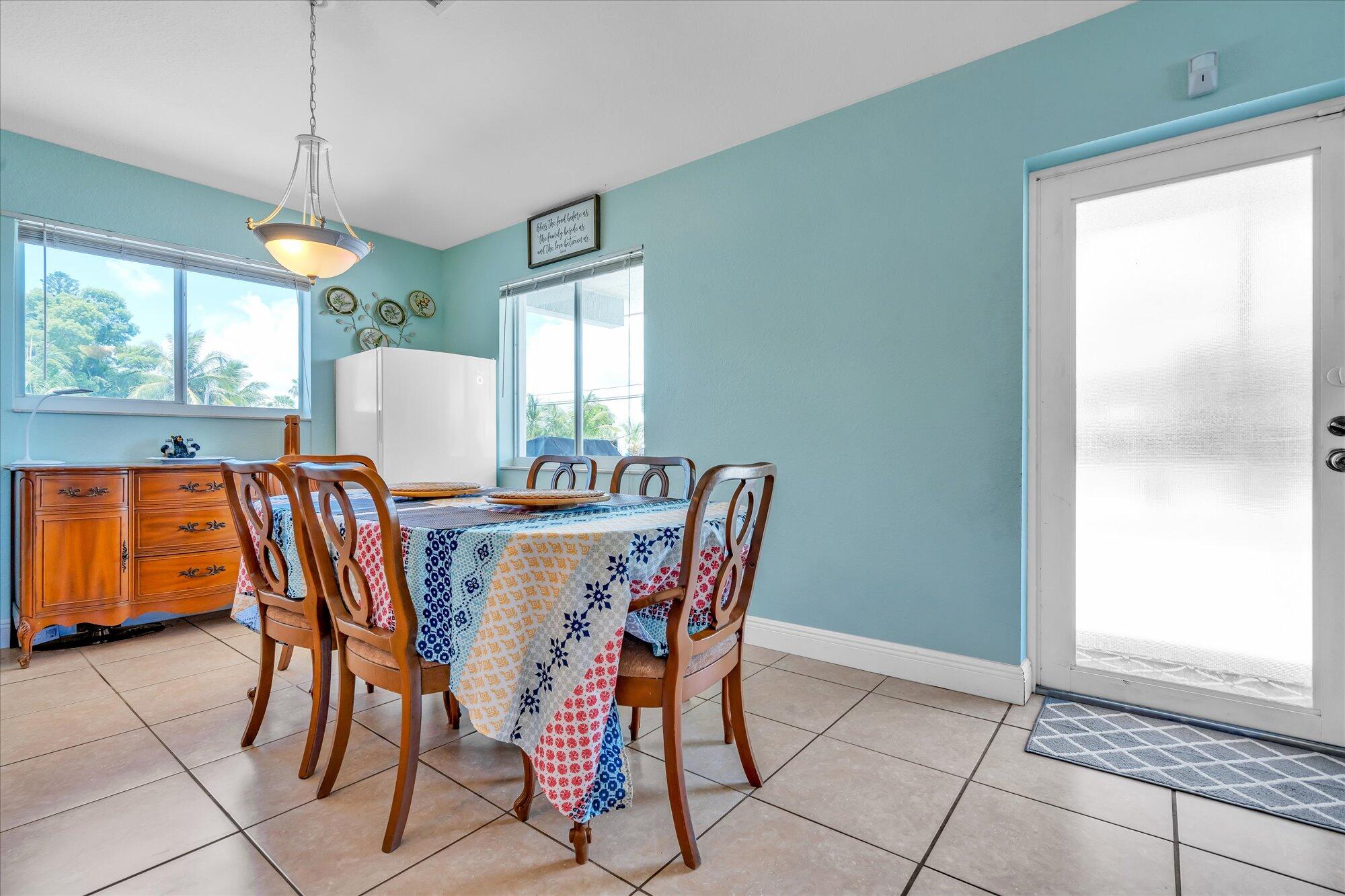939 Plantation Road Key Largo, FL 33037 - Photo 6 of 38 a dining room with furniture a chandelier and window