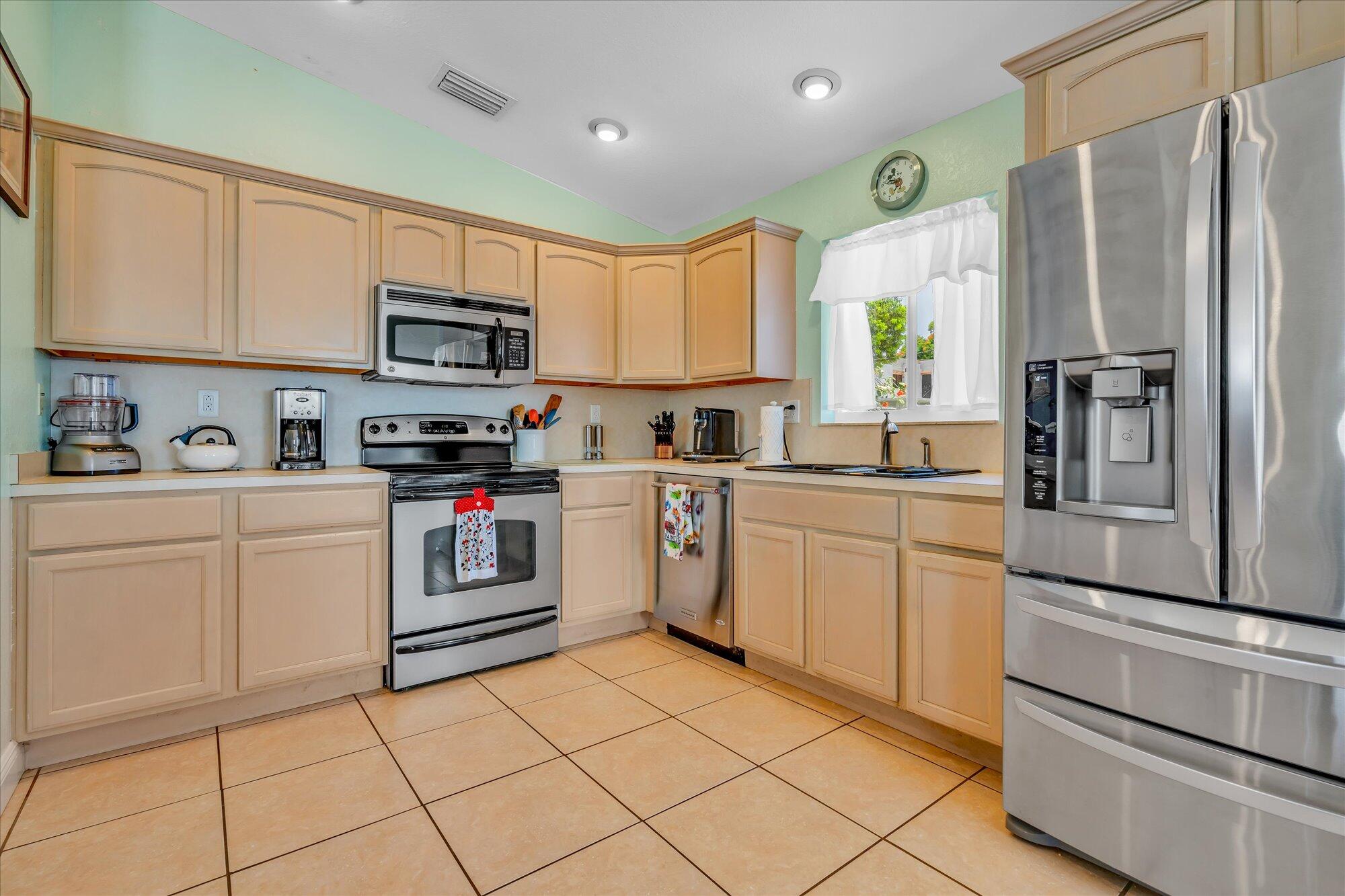 939 Plantation Road Key Largo, FL 33037 - Photo 7 of 38 a kitchen with white cabinets stainless steel appliances and a window