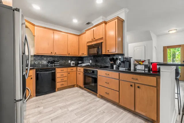 a kitchen with stainless steel appliances granite countertop a refrigerator and a sink