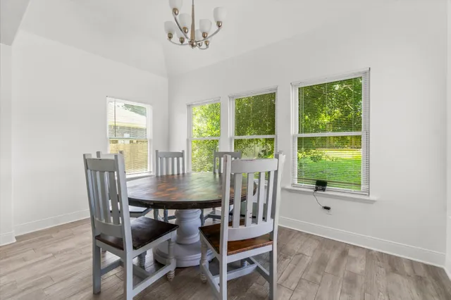 a view of a hallway with wooden floor and windows