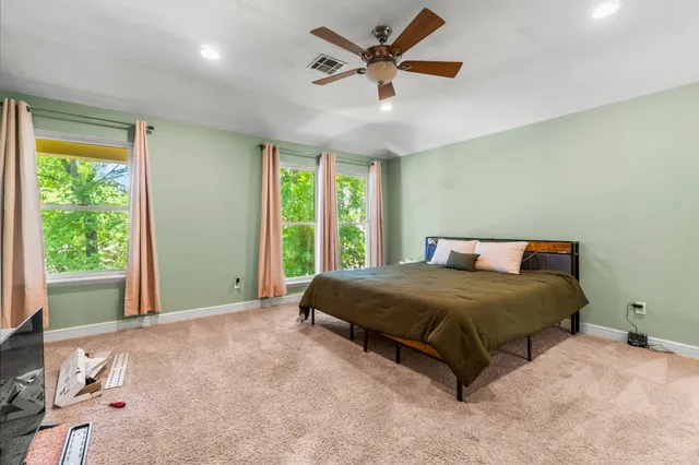 a bedroom with a bed and a ceiling fan