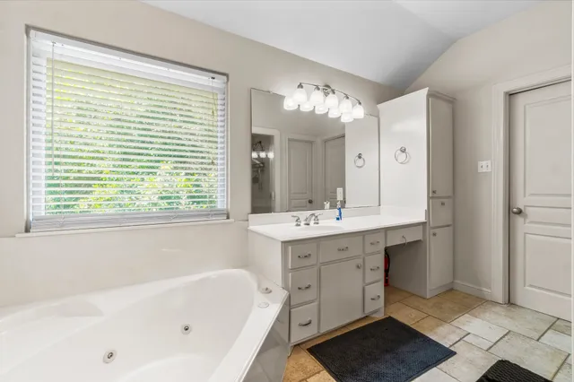 a bathroom with a sink a large mirror and a bathtub