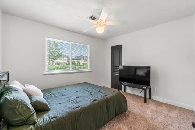a bedroom with a bed and a ceiling fan