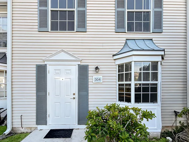 a view of a house with a window and flower plants