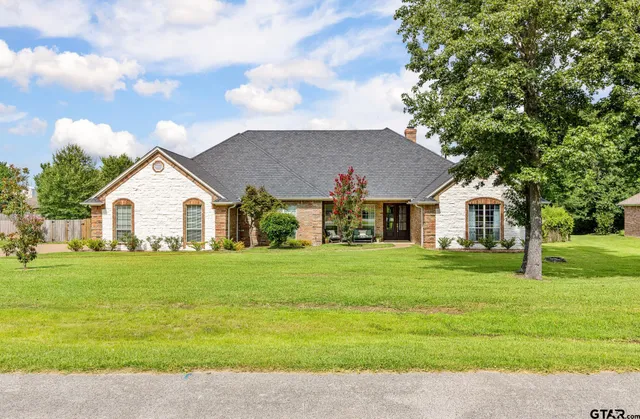 a view of a big house with a big yard and large trees