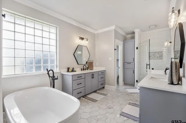a large bathroom with a tub sink and mirror