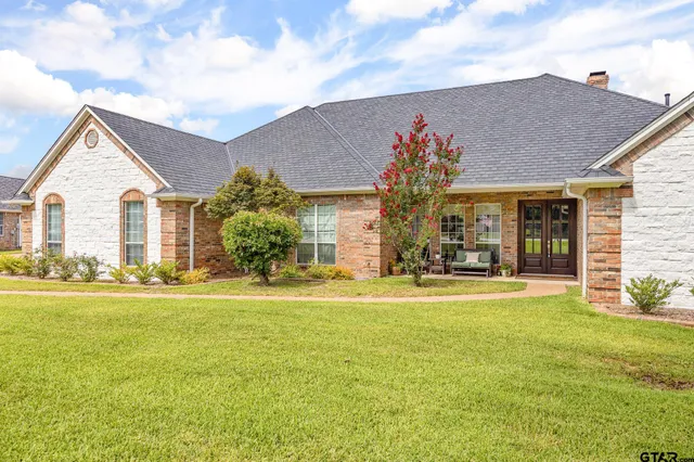 a front view of a house with a garden and yard