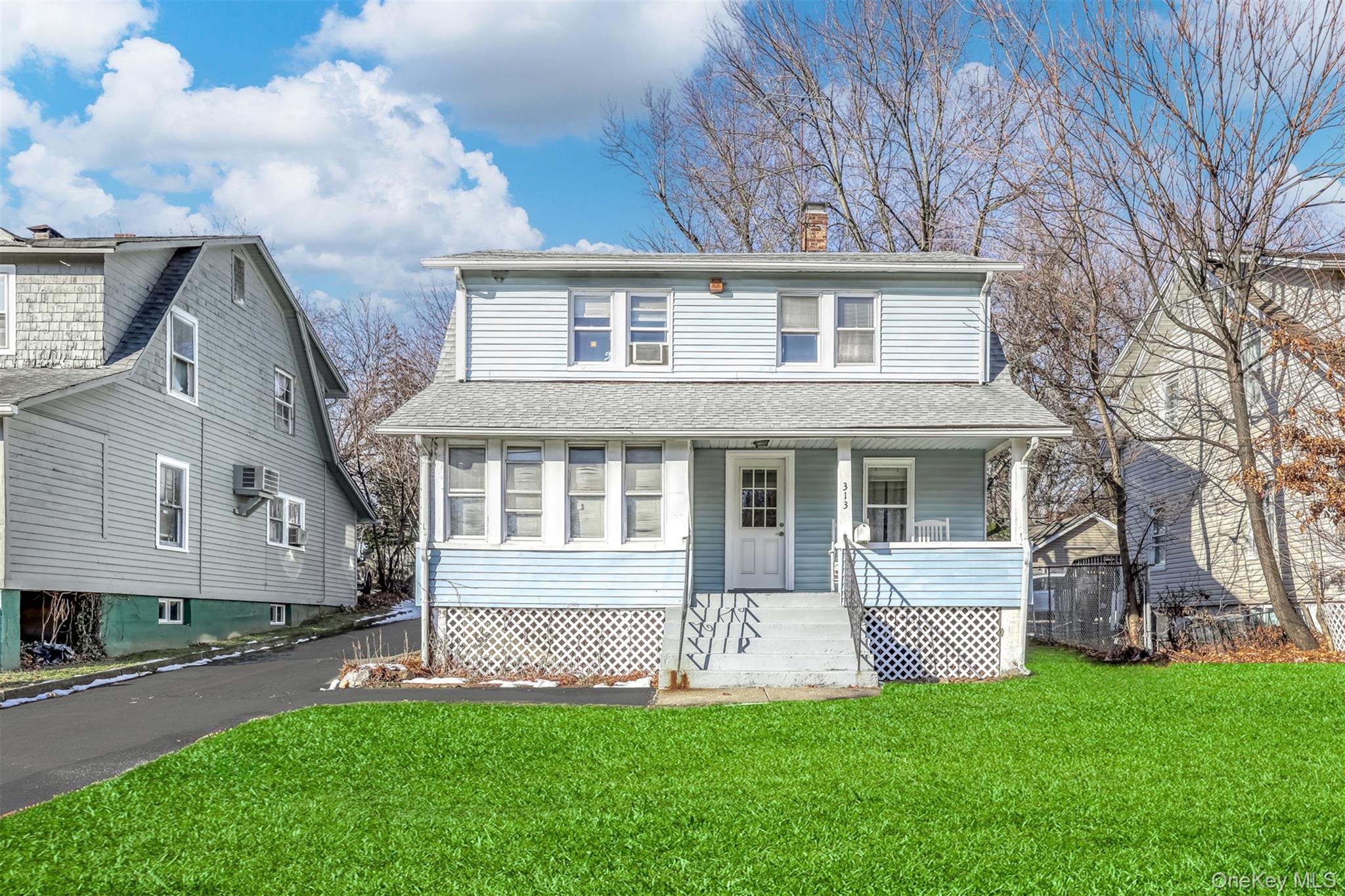 313 North Main Street Spring Valley, NY 10977 - Photo 1 of 19 View of front of home with a front yard, a chimney, a shingled roof, and covered porch