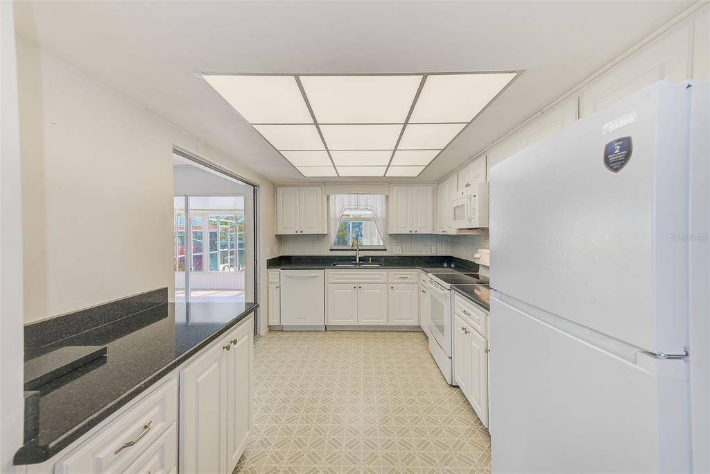 4908 Commonwealth Road Palmetto, FL 34221 - Photo 6 of 15 a large white kitchen with a stove and large window