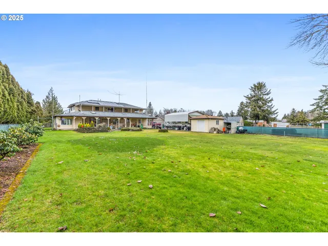 a view of a house with a big yard and large trees