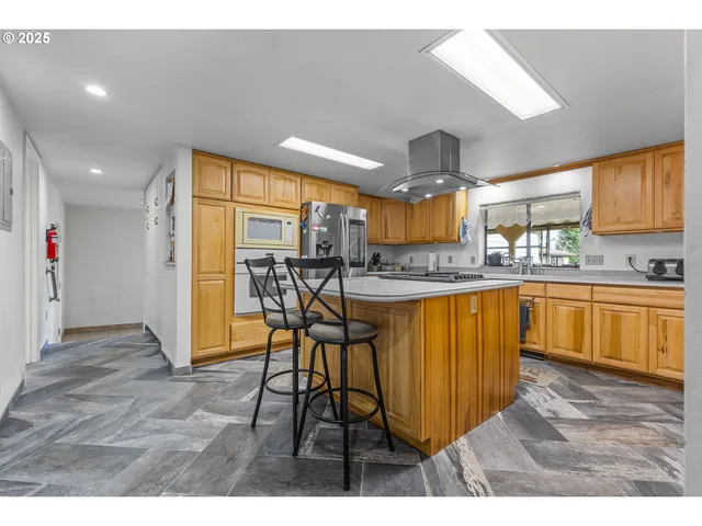 a very nice looking kitchen with a large window appliances and cabinets