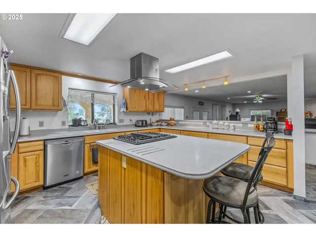 a kitchen with stainless steel appliances granite countertop a sink a stove and a wooden floors