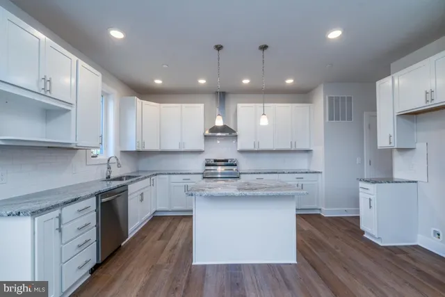 a kitchen with stainless steel appliances granite countertop a white stove top oven and white cabinets