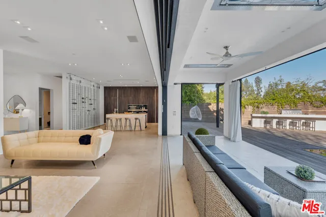 a living room with furniture large window and wooden floor