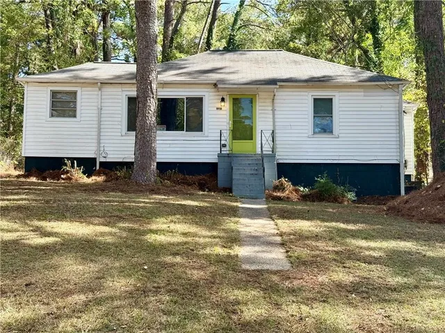 a view of a house with a yard and sitting area