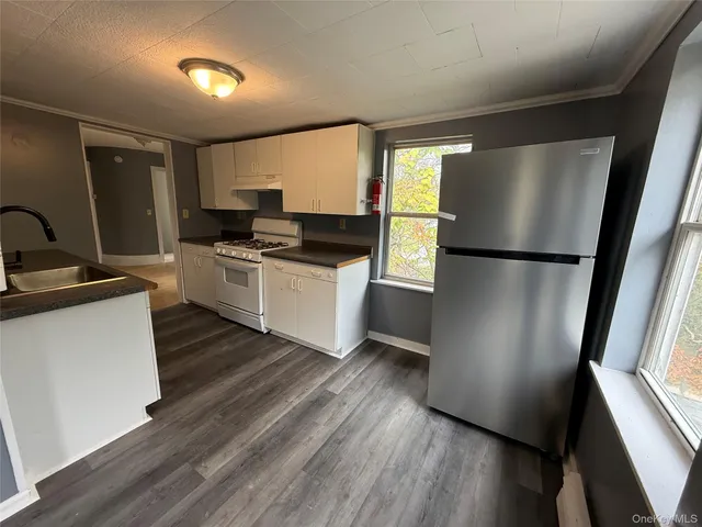 a kitchen with a refrigerator wooden floor and a sink