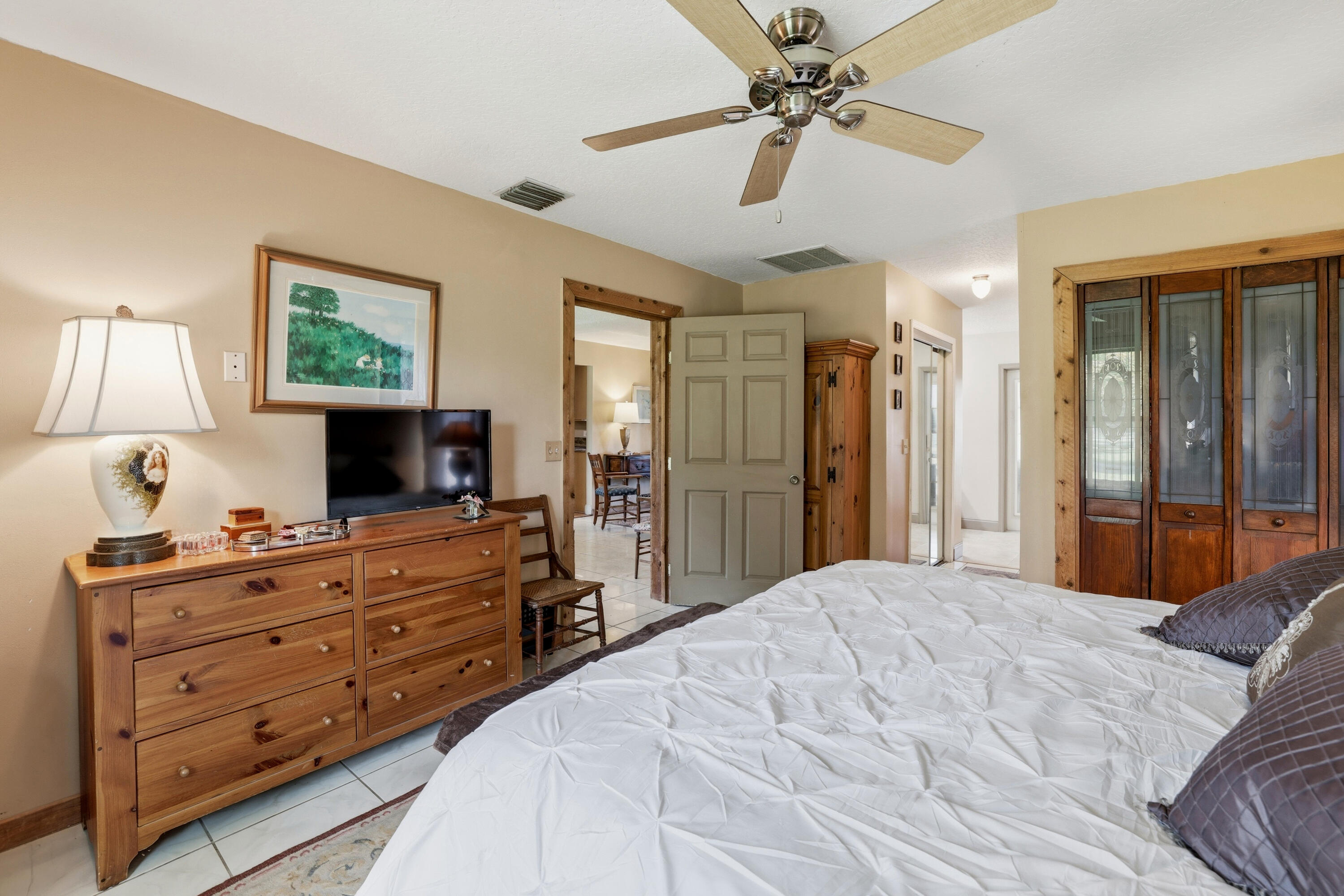 14095 Biddex Road Loxahatchee Groves, FL 33470 - Photo 16 of 69 a bedroom with a bed a window and a flat screen television