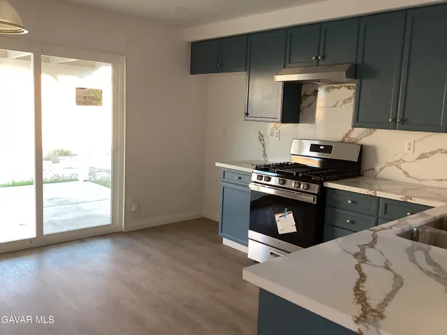 a kitchen with stainless steel appliances a stove a microwave and wooden cabinets