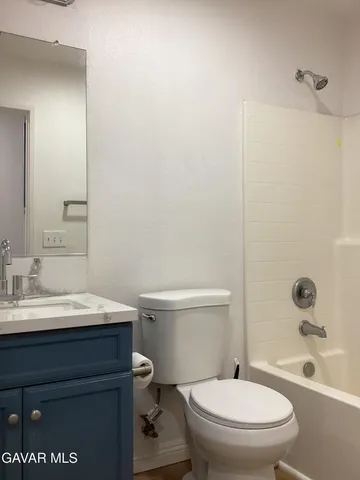 a bathroom with a sink a toilet a mirror and shower