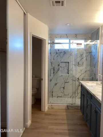 a bathroom with a granite countertop sink mirror and shower