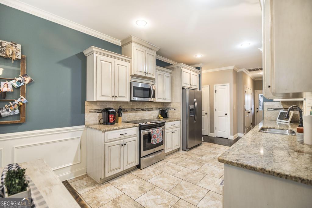 312 Bridgehampton Way Perry, GA 31069 - Photo 13 of 34 a kitchen with stainless steel appliances granite countertop a sink stove and refrigerator