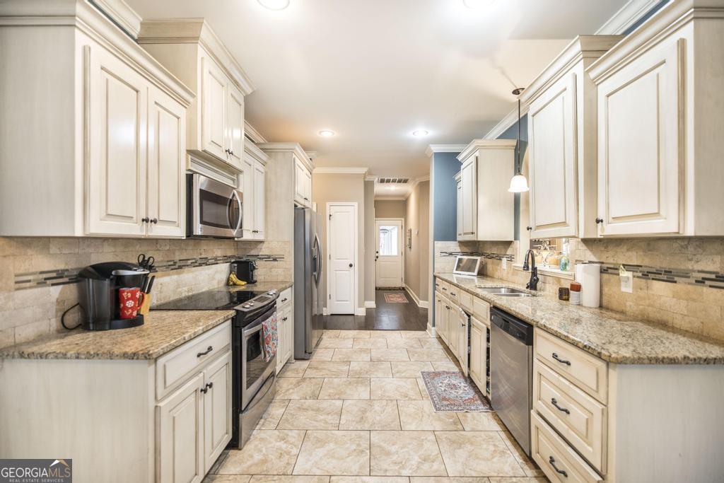 312 Bridgehampton Way Perry, GA 31069 - Photo 14 of 34 a kitchen with stainless steel appliances granite countertop a stove a sink dishwasher and a refrigerator