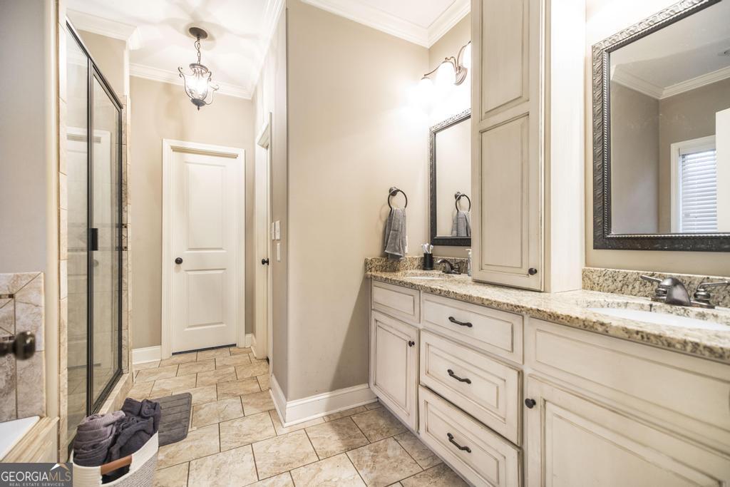 312 Bridgehampton Way Perry, GA 31069 - Photo 20 of 34 a bathroom with a granite countertop sink a mirror and a shower