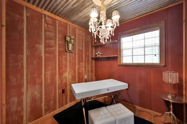 a view of a dining room with furniture a chandelier and window